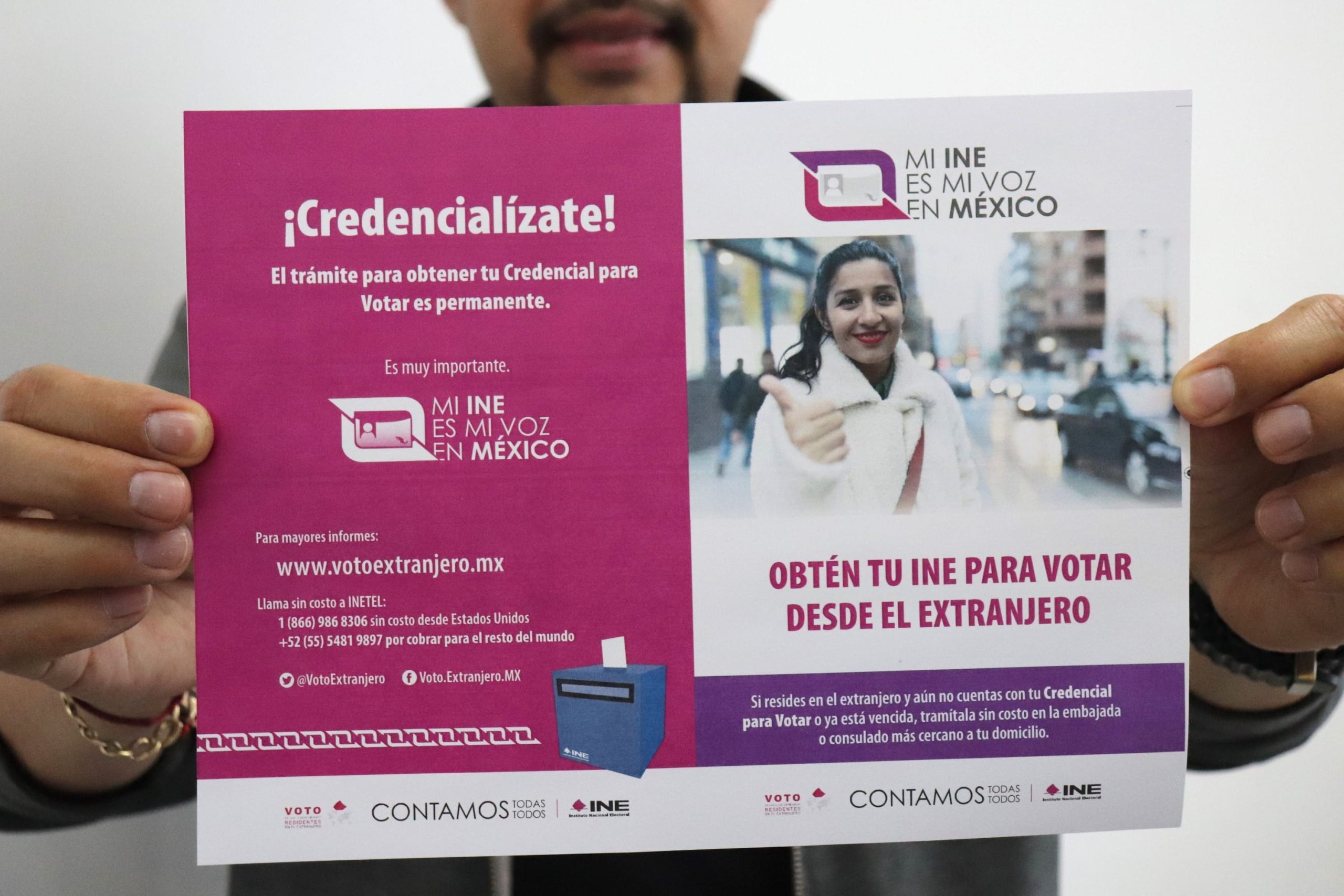 un hombre sosteniendo un cartel de credencialización en el Extranjero