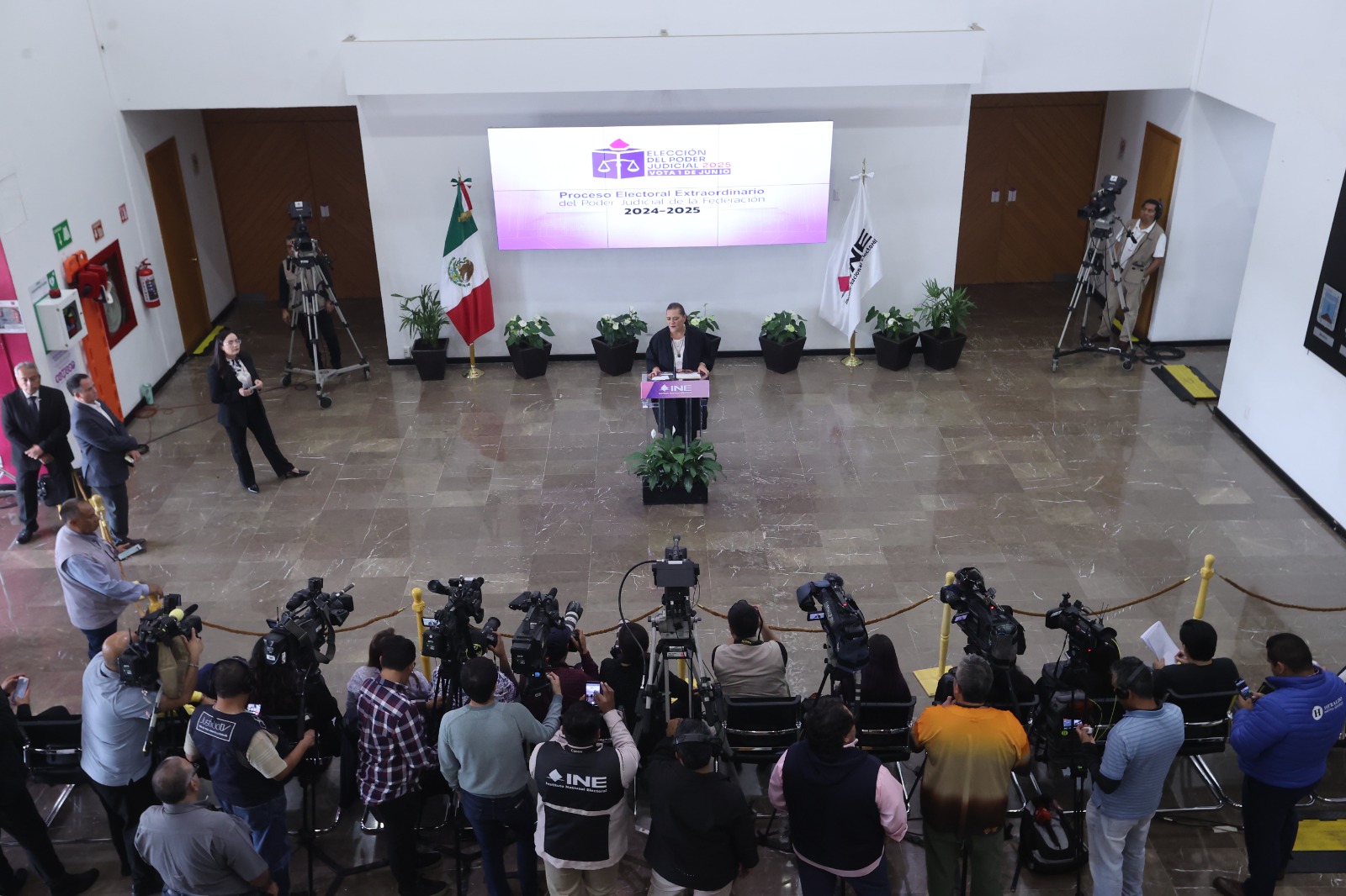 Imagen del lobby con la Consejera Presidenta Guadalupe Taddei Zavala de pie parada en pódium.