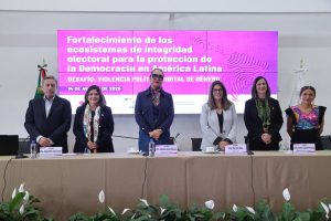 Personas participantes en el evento paradas en el estrado.