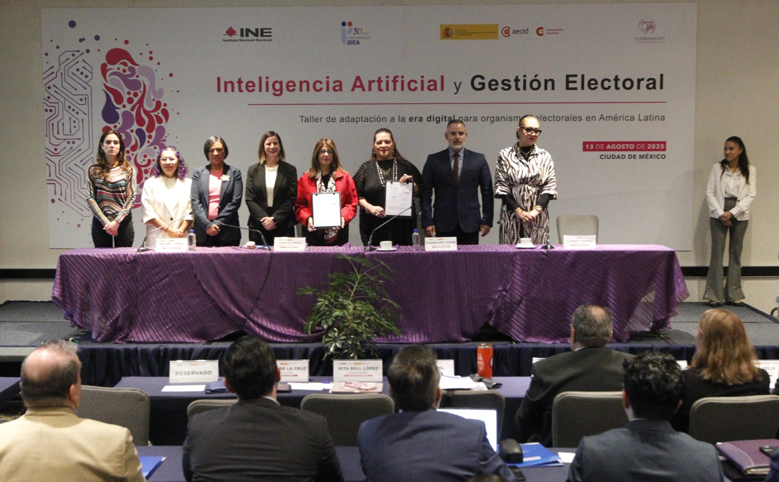 Personas participantes en el evento posando con el memorándum en las manos.