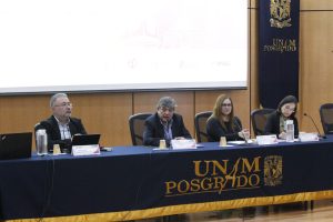 Personas participantes del evento, sentados en el estrado.