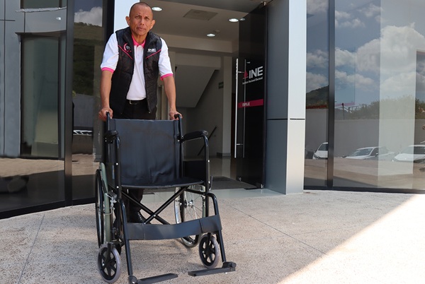 Hombre de pie atrás de una silla de ruedas