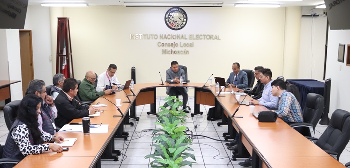 personas sentadas alrededor de mesa con micrófonos