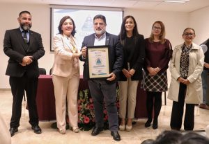 seis personas de pie sosteniendo un reconocimiento