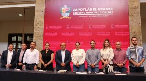 varias personas de pie frente a una pared roja