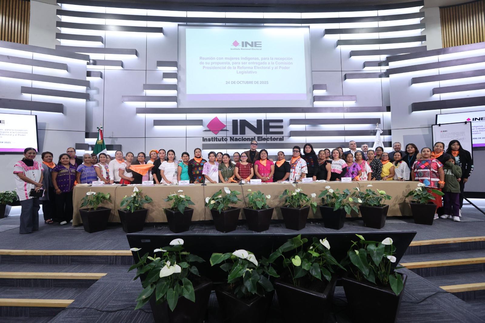 Personas participantes paradas al frente de la audiencia en el auditorio del Instituto.