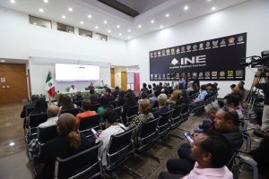 Imagen abierta en el lobby del instituto con las personas participantes sentadas al frente de la audiencia.