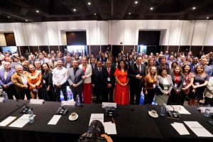 Imagen abierta en el salón del evento con las personas participantes posando para la foto.