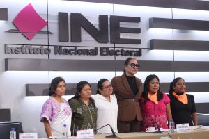 Personas participantes paradas en el estrado del auditorio del instituto.