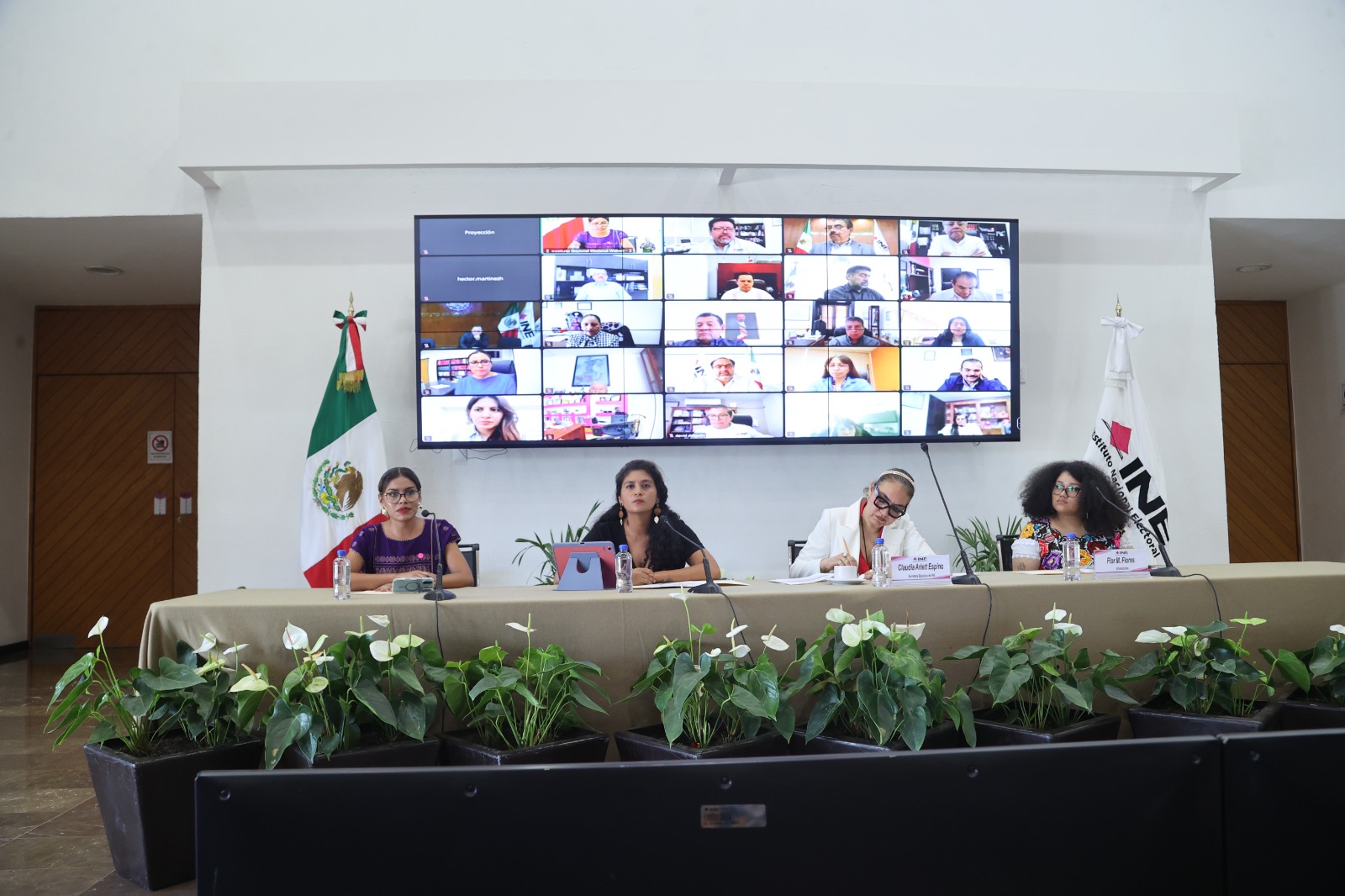 Participantes sentadas en el estrado frente a la audiencia.