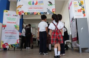 menores de edad formados abajo de una cartel de colores