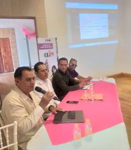 cuatro personas sentada frente a una mesa con mantel rosa