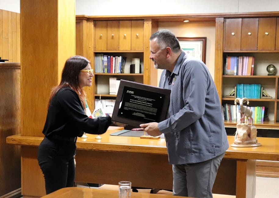 una mujer entregando un reconocimiento a un hombre