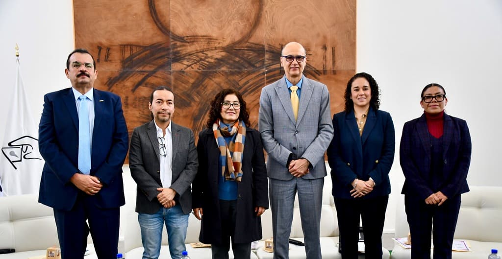 seis personas de pie frente a un cuadro café