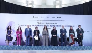 varias personas de pie en el escenario de un auditorio