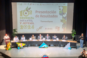 varias personas sentadas frente a una pantalla grande