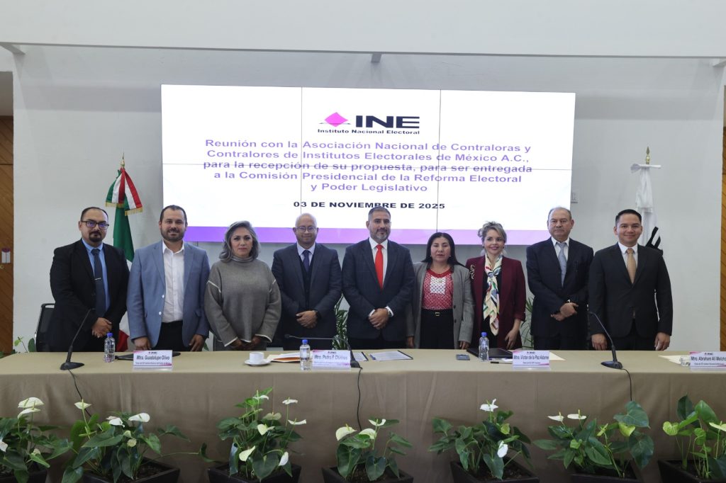 Participantes del evento parados en el estrado posando para la foto oficial.