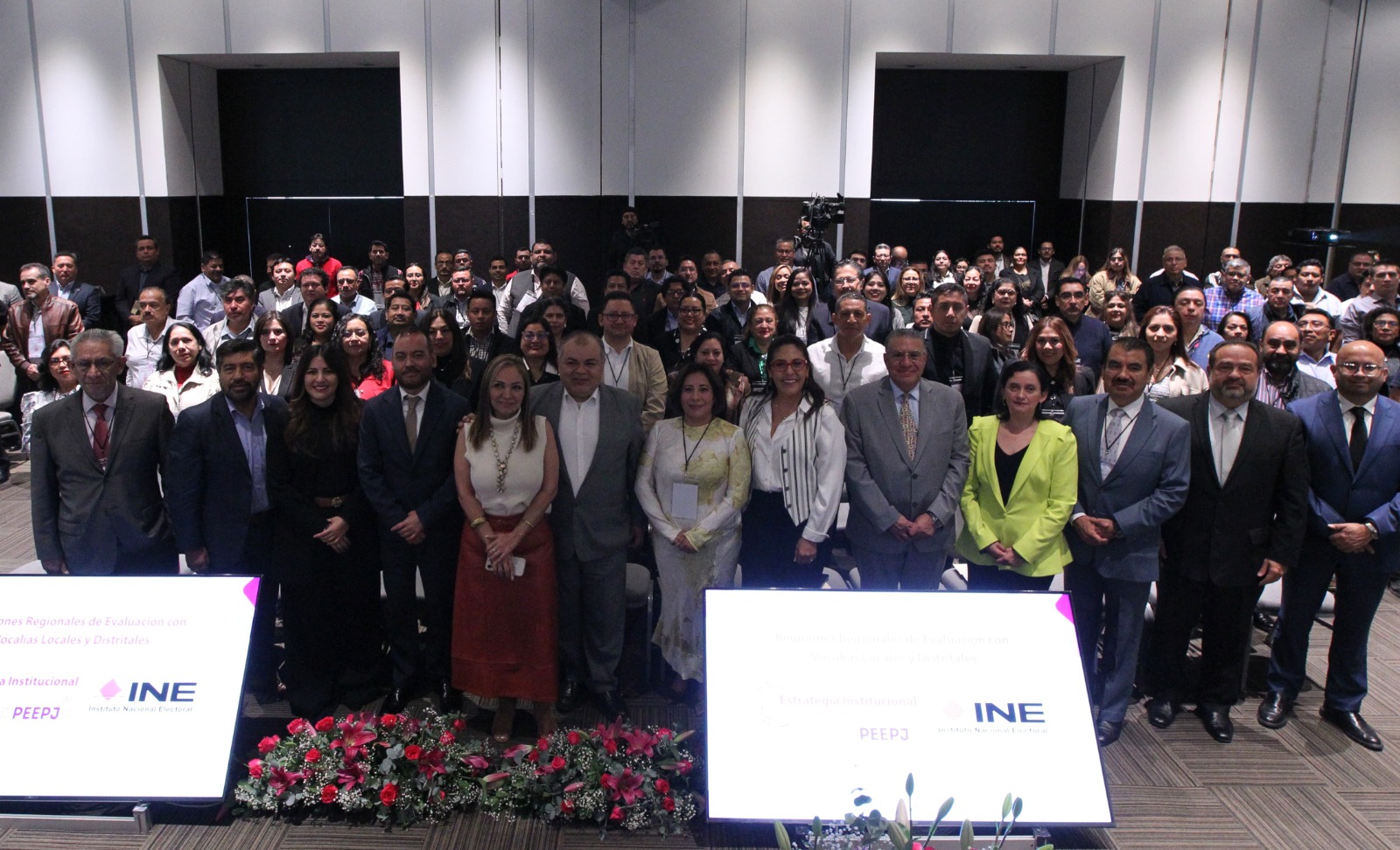 Persona participantes paradas posando para la foto oficial en el salón.