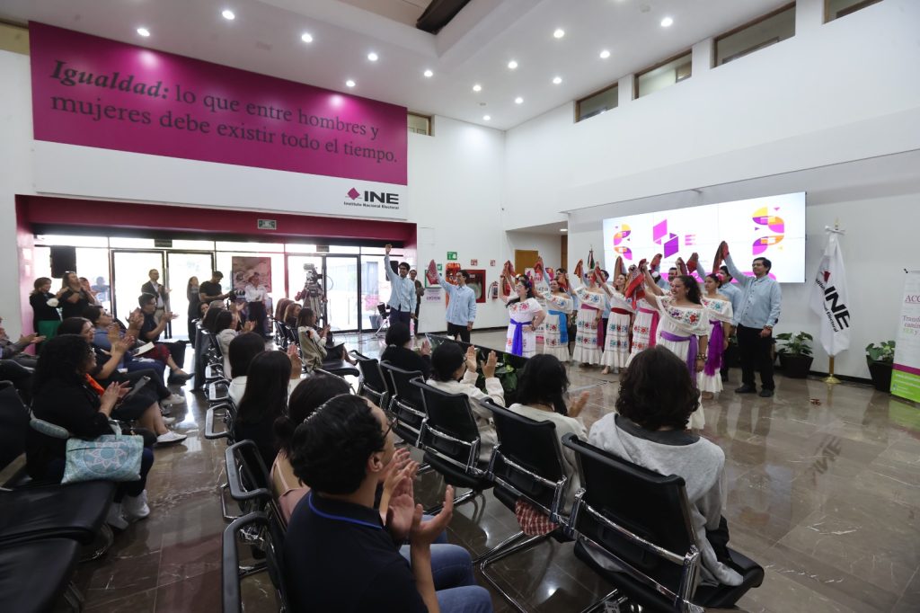 Personas bailando y cantando con trajes regionales.