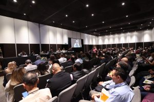 Persona participantes y público asistente sentadas en el salón durante su participación en el evento.