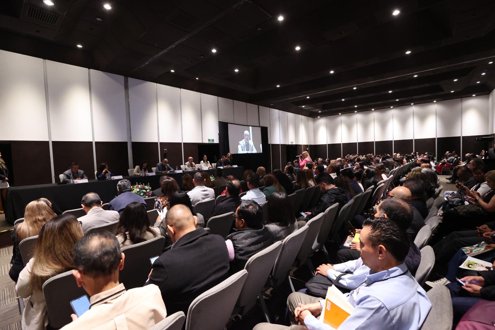 Persona participantes y público asistente sentadas en el salón durante su participación en el evento.