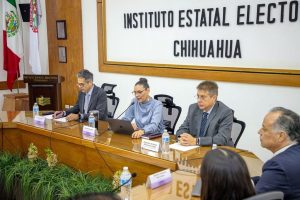 cinco personas sentadas alrededor de una mesa rectangular