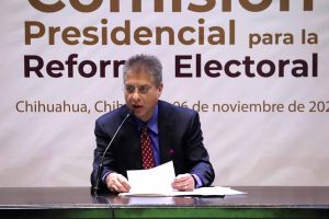 hombre sentado hablando frente a micrófono