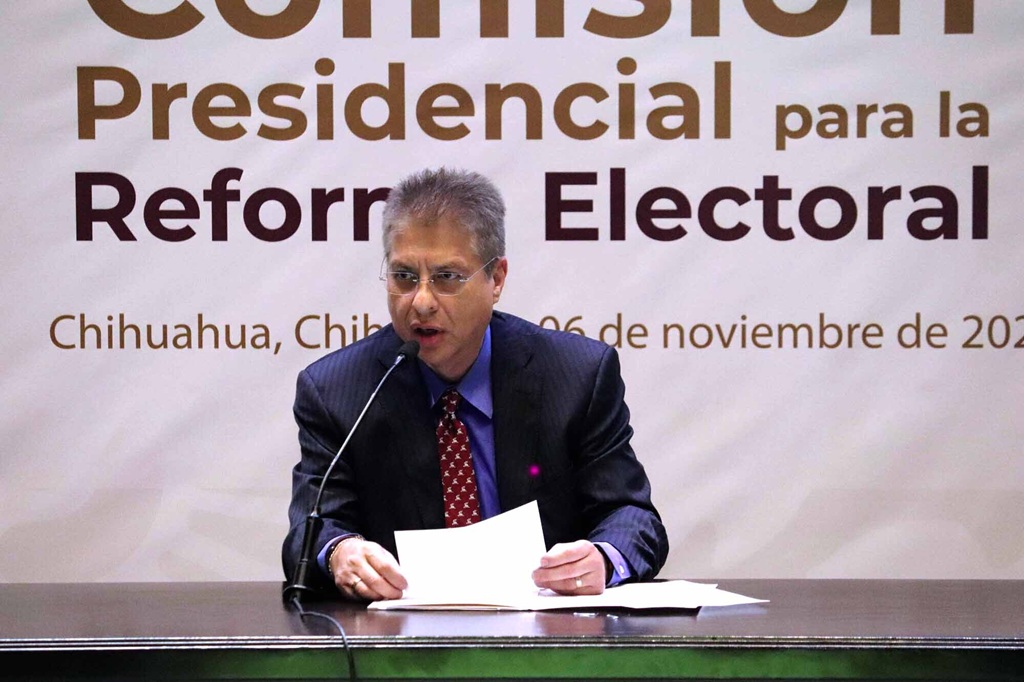 hombre sentado hablando frente a micrófono