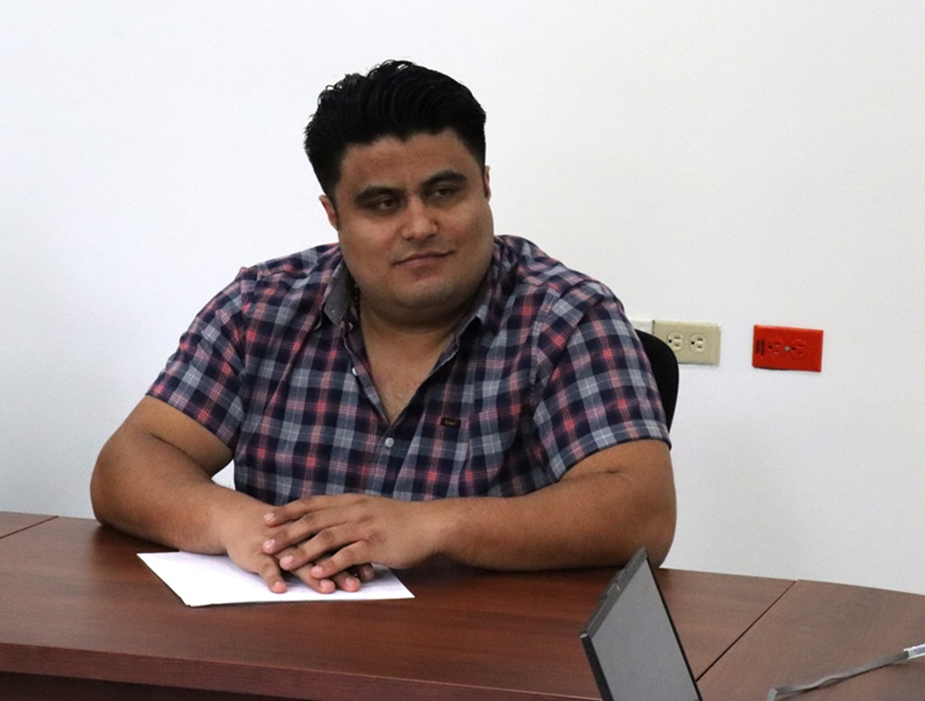 hombre cabello negro camisa a cuadros sentado