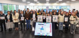 muchas personas de pie sosteniendo carteles en un salón