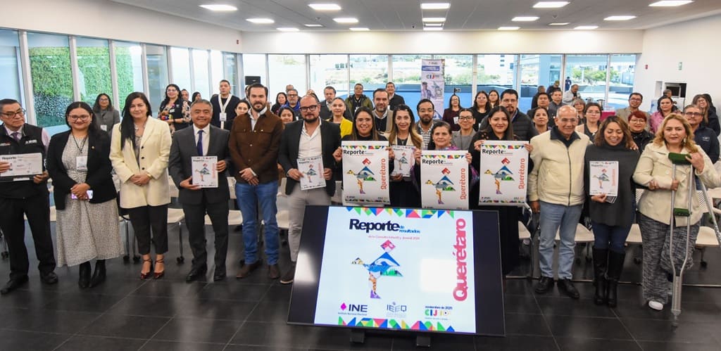 muchas personas de pie sosteniendo carteles en un salón