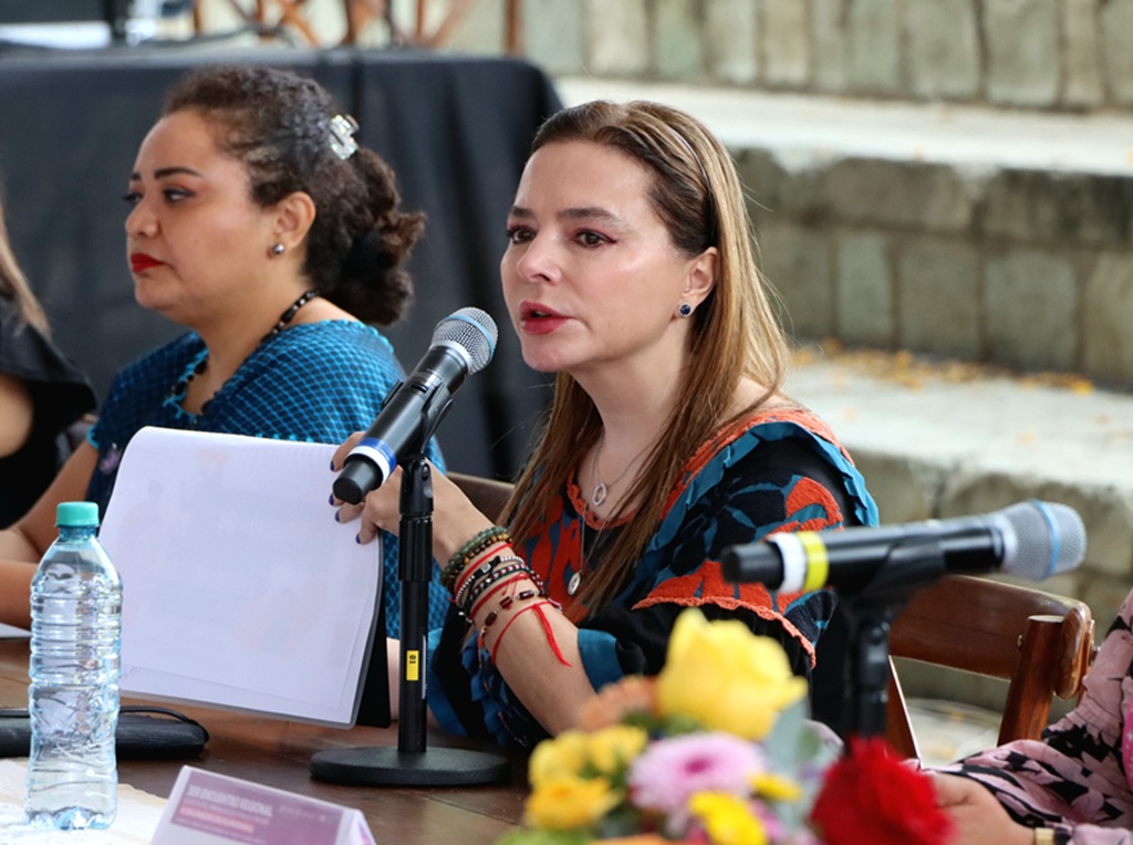 mujer hablando frente a un micrófono