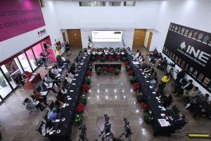 Toma abierta del Lobby del instituto persona participantes sentadas frente al público asistente.