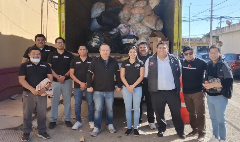 9 hombres y una mujer de pie atrás de un camión con cajas