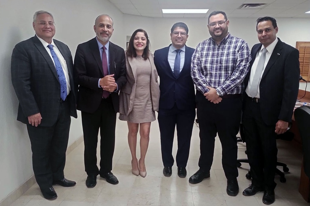 cinco hombres y una mujer de pie posando para la foto
