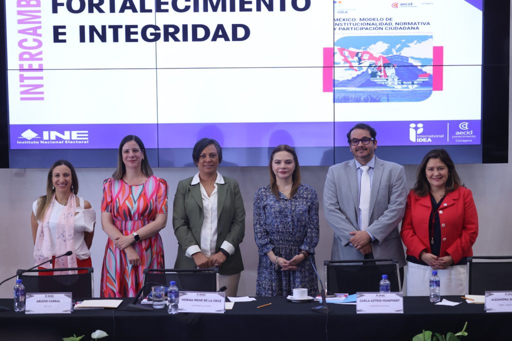 Personas participantes paradas en el estrado del Lobby posando para la foto.