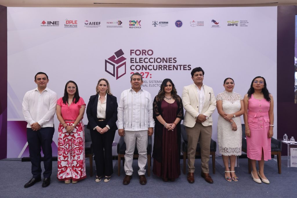 Personas participantes paradas en el estrado posando para la foto oficial.