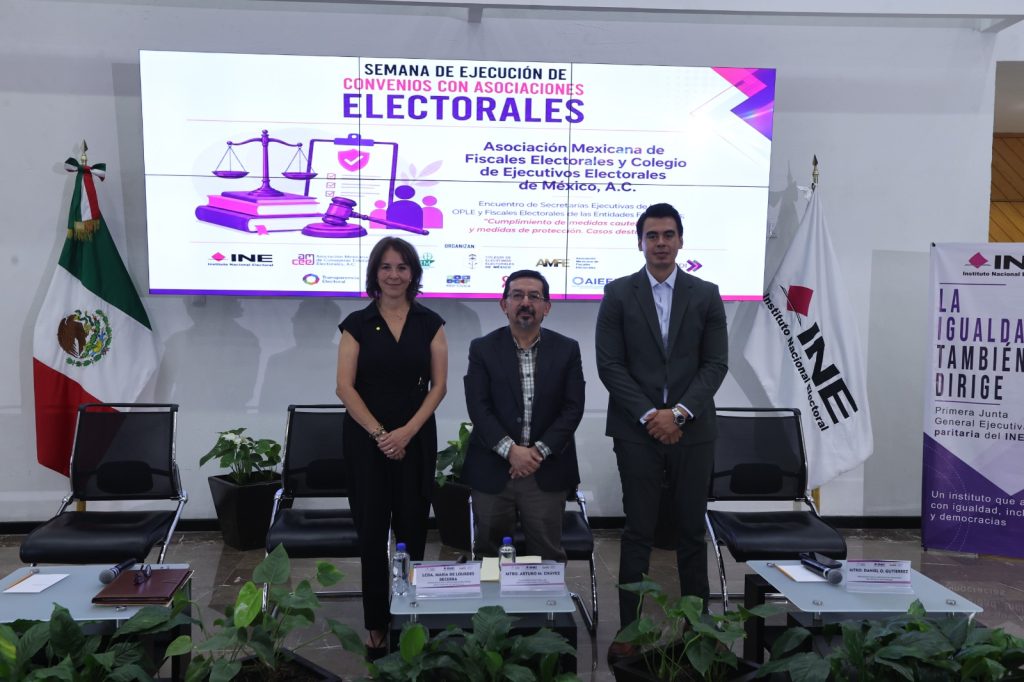 Personas participantes paradas en el estrado posando para la foto.
