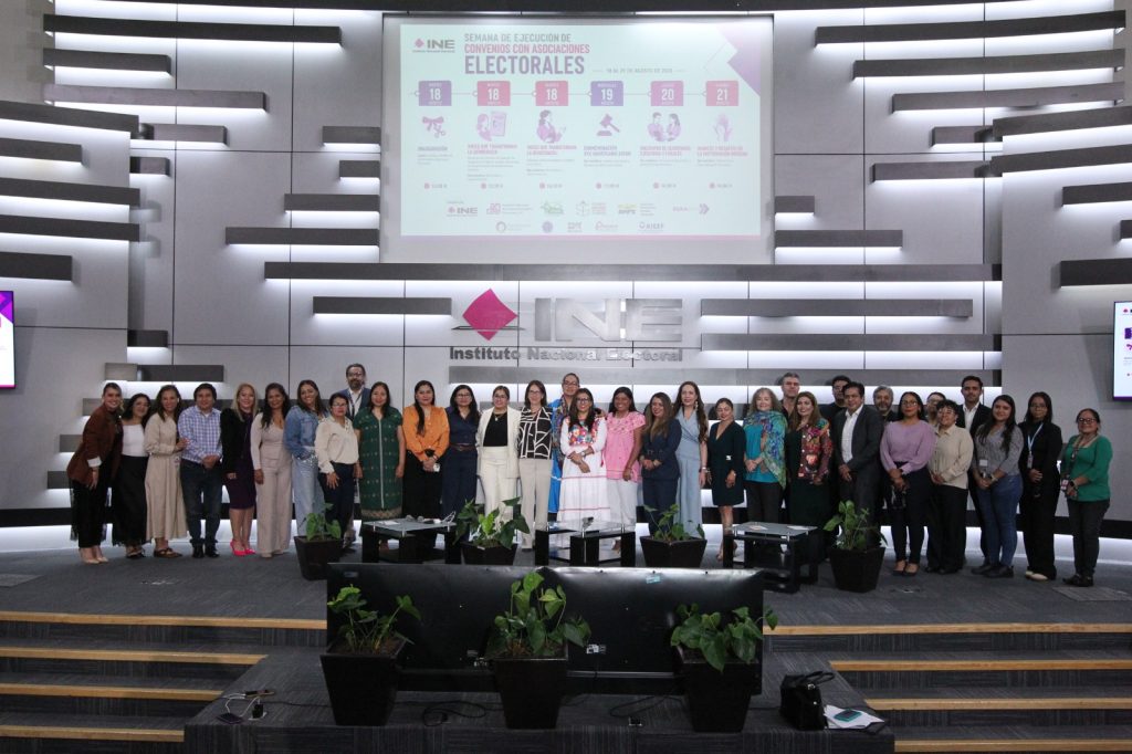 Personas participantes paradas en el estrado posando para la foto.