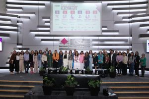Personas participantes paradas en el estrado del auditorio posando para la foto.