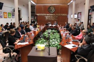 varias personas sentadas alrededor de una mesa en un salón color madera