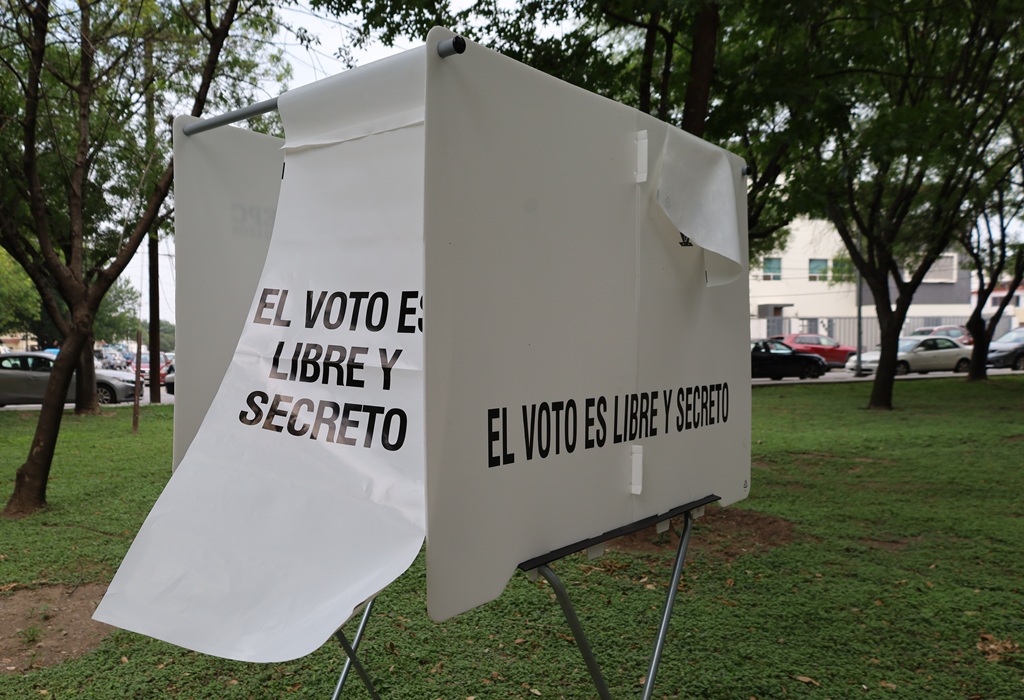 mampara blanca en un parque con leyenda en letras negras el voto es libre y secreto