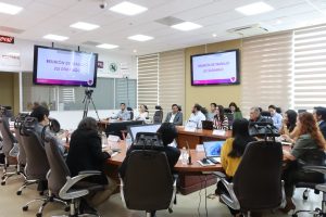 varias personas sentadas alrededor de una mesa ovalada