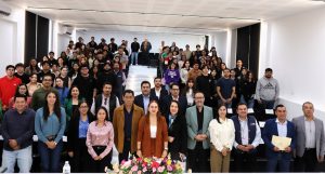 personas de pie en un auditorio posando para la fotografía