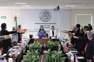 varias personas en un salón de pie con el brazo extendido al frente