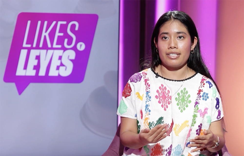 Mujer indígena murando a la pantalla en el programa Likes Y Leyes