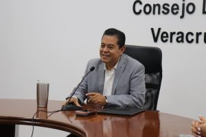hombre sentado frente a un micrófono sonriendo