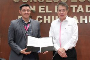 dos hombres de pie, uno sostiene un diploma