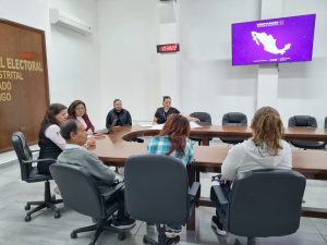 seis personas sentadas alrededor de una mesa ovalada de madera