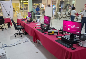 mesas con mantel rosa y computadoras